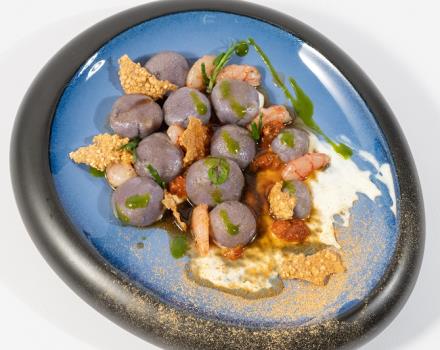 Salsedine bonbon di patata viola su caramello piccante di crostacei, ricci di mare e gambero rosso