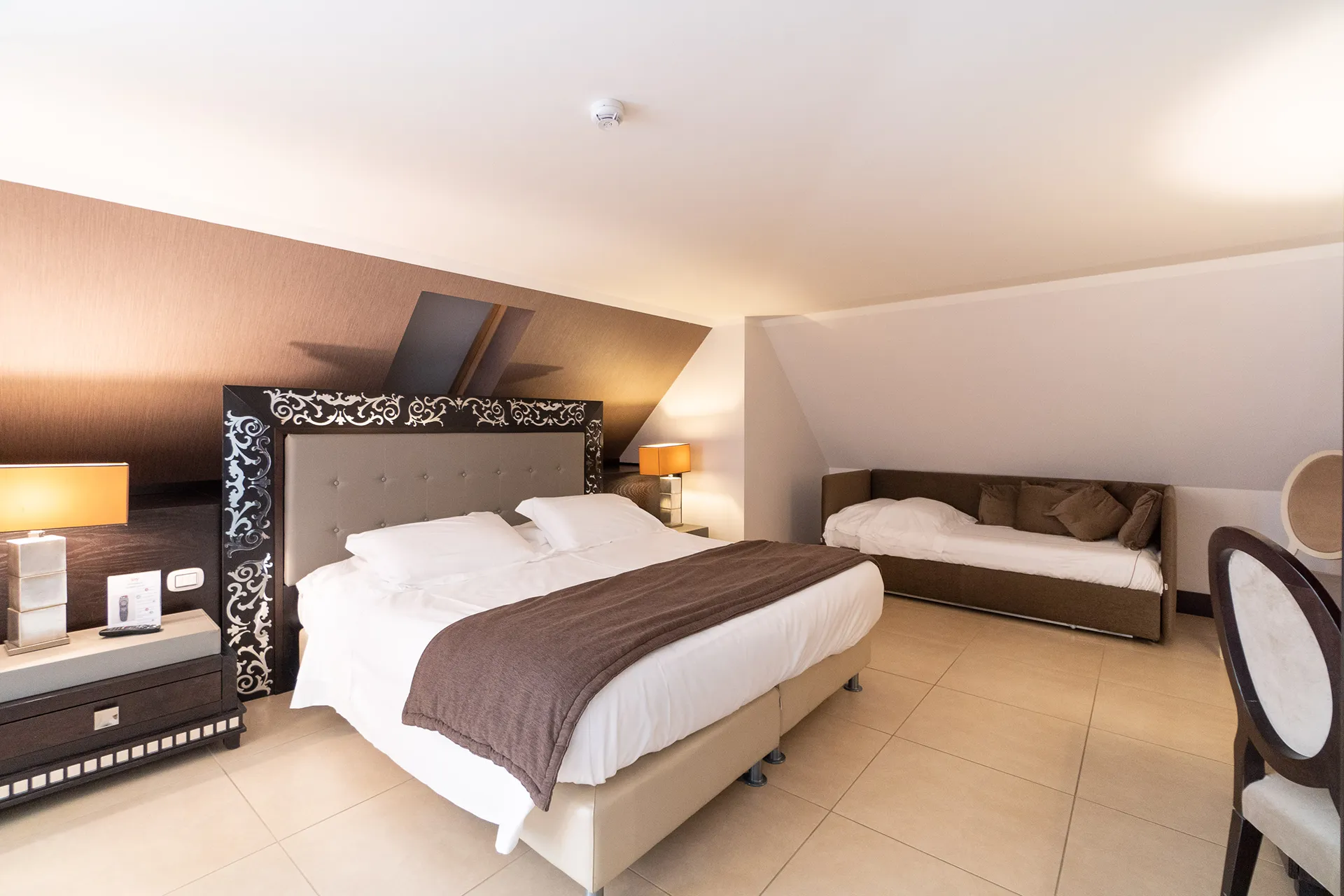 Nell'immagine una camera finestrata con letto matrimoniale e letto singolo